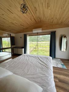 a bedroom with a large bed with a large window at Villa Nar in Cıralı