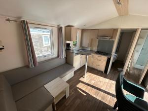 a small kitchen with a table and a window at MobilHome 3 chambres 6 personnes Piscine Camping Saint Cheron in Saint-Chéron