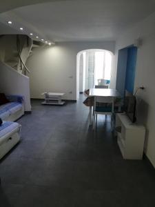 ein Wohnzimmer mit einem Tisch und einem Sofa in der Unterkunft STELLA MARINA in Procida