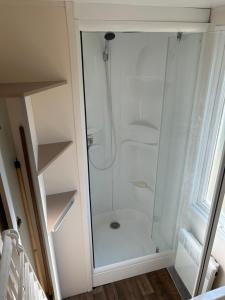 a shower with a glass door in a bathroom at MobilHome 3 chambres 6 personnes Piscine Camping Saint Cheron in Saint-Chéron