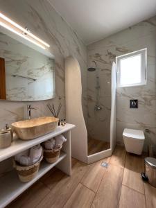 a bathroom with a sink and a shower at Katerina Apartments & Studios in Naousa