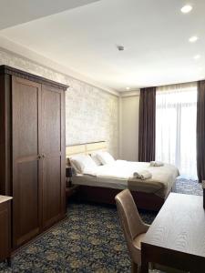 a hotel room with two beds and a window at Marmenio Hotel - Tbilisi in Tbilisi City