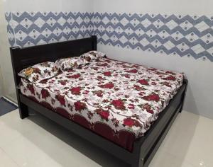 a bed with a floral comforter on top of it at SAMPATH RESIDENCY in Palani
