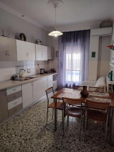 a kitchen and dining room with a table and chairs at Olena House in Kavala