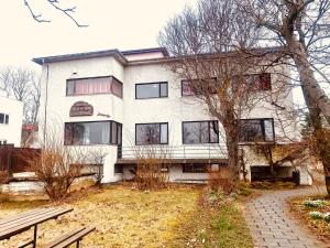 uma casa branca com uma árvore em frente em Travel Inn em Reykjavík