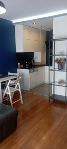 Una sala de estar con una mesa y una cocina. en Apartament Komfort, en Zamość