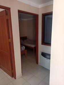 a hallway with a room with a bed and a door at Lugar encantador en Tarija Bolivia in Tarija