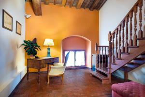 a living room with a staircase and a desk at Villa Pitiana in Donnini