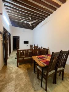 una sala da pranzo con tavolo, sedie e soffitto di Beytsalaam Apartments a Lamu