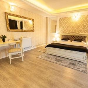 a bedroom with a bed and a desk and a mirror at Grand Hotel Baroc in Zalău