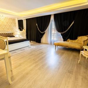 Grand Hotel Baroc في زالاو: غرفة نوم بسرير وطاولة وكراسي
