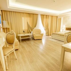 una grande camera da letto con un letto e una sedia di Grand Hotel Baroc a Zalău