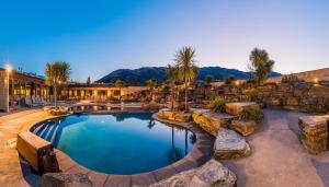 a swimming pool in a resort with a rock wall at Oakridge Resort Lake Wanaka in Wanaka