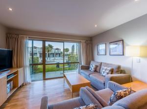 sala de estar con sofá y TV en Oakridge Resort Lake Wanaka, en Wanaka