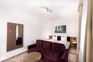 ein Hotelzimmer mit einem Bett und einem Sofa in der Unterkunft Firzlaff's Hotel in Neumünster