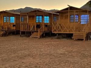 a group of wooden huts in the desert at Sina Star Camp in Nuweiba