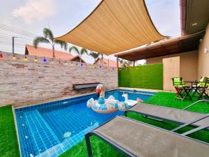 a small swimming pool with an inflatable raft and a table and chairs at SilverGold PoolVilla in Jomtien Beach