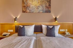 a bedroom with two beds and a painting on the wall at Kurpension Freudenstein in Bad Füssing +37 photos