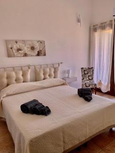 a bedroom with a bed with two black towels on it at casa vacanza V&G in Domus de Maria