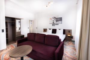 ein Wohnzimmer mit einem Sofa und einem Bett in der Unterkunft Firzlaff's Hotel in Neumünster