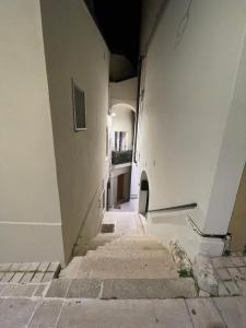 泰爾莫利的住宿－La Finestra Sul Porto，一条空洞的小巷,有白色的建筑和楼梯