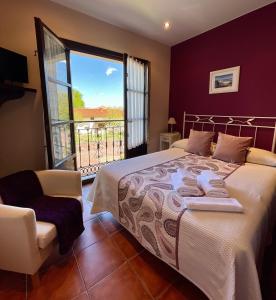 1 dormitorio con 1 cama grande y balcón en Hotel Rural El Texeu, en Llanes