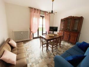 sala de estar con sofá, mesa y sillas en Appartamento Bellavista - Fronte Lago di Varese en Gavirate
