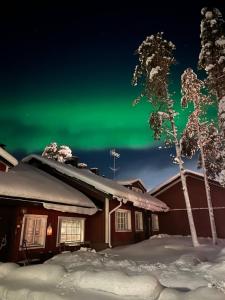 a house with the green northern lights in the sky at One-bedroom apartment in the center of Saariselkä in Saariselka