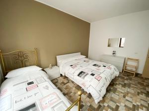 1 dormitorio con 2 camas y espejo en Appartamento Bellavista - Fronte Lago di Varese en Gavirate