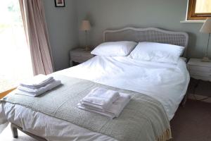 a bedroom with a bed with two towels on it at River Cottage - Stunning estuary views in Aldeburgh