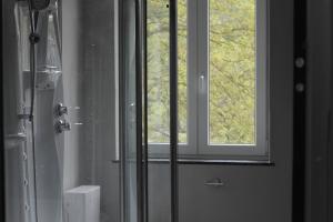 La salle de bains est pourvue d'une douche et d'une fenêtre. dans l'établissement Liotte'sCorner Guesthouse, à Sprimont