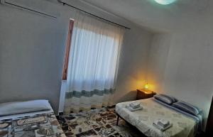 a small room with two beds and a window at janas in Tortolì