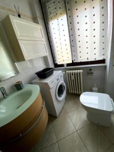 y baño con lavabo y lavadora. en Appartamento Bellavista - Fronte Lago di Varese en Gavirate