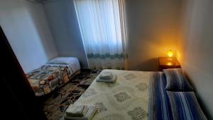 una piccola camera con due letti e una finestra di janas a Tortolì