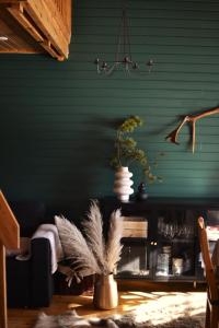 a living room with green walls and a vase with feathers at One-bedroom apartment in the center of Saariselkä in Saariselka