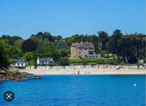 ein Strand mit einem großen Haus und Menschen darauf in der Unterkunft MH Kerlann 4* Finistère Sud 237 in Pont-Aven