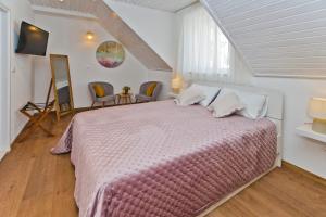 ein Schlafzimmer mit einem großen Bett mit einer rosa Decke in der Unterkunft *Beautiful, centrally located studio apartment* in Hvar