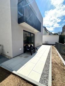 a patio with a black chair on a building at Weinberg-Design-Apartment Stuttgart-Fellbach in Fellbach