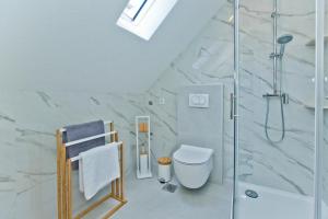 ein weißes Bad mit einer Dusche und einem WC in der Unterkunft *Beautiful, centrally located studio apartment* in Hvar