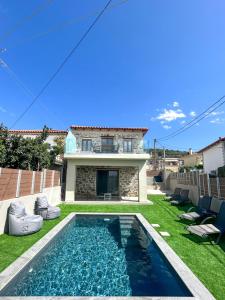 a backyard with a swimming pool and a house at Piedra Luxury Apartments in Nafplio