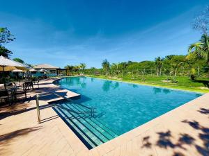馬塔迪聖若昂的住宿－Estudio Top Praia do Forte，一个带桌椅的大型游泳池