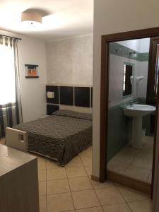 a bedroom with a bed and a sink and a mirror at B&B Agrodolce in San Vito lo Capo