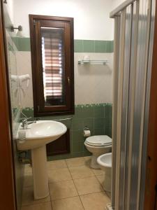 uma casa de banho com um lavatório e um WC em B&B Agrodolce em San Vito lo Capo