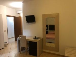 una camera con tavolo, specchio e letto di B&B Agrodolce a San Vito lo Capo