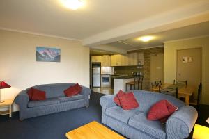 a living room with two couches and a kitchen at Attunga Alpine Lodge & Apartments in Falls Creek
