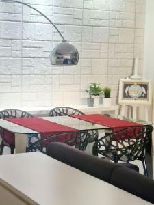 a dining room with a red table and chairs at Energy Home in Palermo