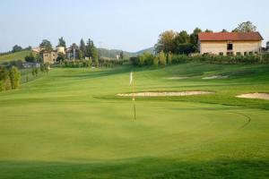 uma vista para um campo de golfe verde com uma bandeira em Mini suite del borgo antico em Novi Ligure
