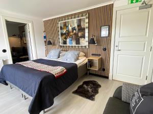 ein Schlafzimmer mit einem Bett und einem Wandgemälde in der Unterkunft Skaftö Hotell Villa Lönndal, Grundsund in Grundsund