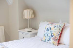 チェルトナムにあるSpacious 3BR Victorian Cheltenham loft flat in Cotswolds Sleeps 8 - FREE Parkingのベッド(枕付)、ランプが備わります。
