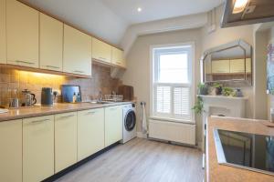 kuchnia z białymi szafkami i pralką w obiekcie Spacious 3BR Victorian Cheltenham loft flat in Cotswolds Sleeps 8 - FREE Parking w mieście Cheltenham